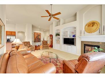 Spacious living room with built in shelves, a fireplace, and carpet flooring at 9784 S Iris Ct, Littleton, CO 80127