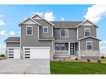 Charming gray two-story home with a three-car garage and manicured lawn at 42958 Colonial Trl, Elizabeth, CO 80107