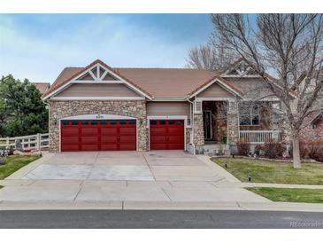 Charming home featuring stone accents, red garage doors, and a well-maintained lawn at 21270 E Eldorado Dr, Aurora, CO 80013
