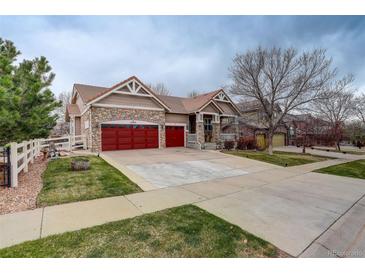 Charming exterior with stone accents, red garage doors, and a well-manicured lawn at 21270 E Eldorado Dr, Aurora, CO 80013