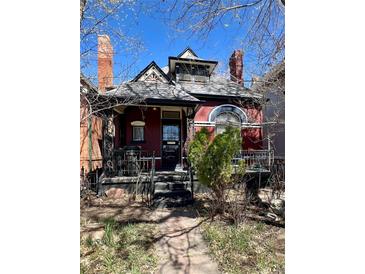 Charming red two-story home with a beautiful porch and black ornate railings at 231 W Ellsworth Ave, Denver, CO 80223