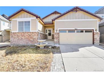 Charming home featuring a brick facade, a two-car garage and a well-maintained yard with mature landscaping at 9814 Norfolk St, Commerce City, CO 80022