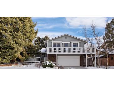 Two-story house with a deck, attached garage, and snowy landscaping at 3420 S Nucla Way, Aurora, CO 80013