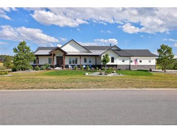 Beautiful two-story home with a green lawn, lovely landscaping, and a charming covered entryway at 2705 Fox View Trl, Franktown, CO 80116