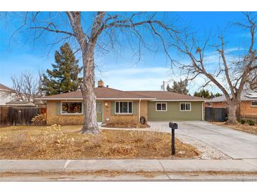 Ranch style home with a green exterior, mature trees, and a paved driveway at 290 Pierce St, Lakewood, CO 80226