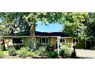 Charming single-story home with brick and siding, lush landscaping, and mature trees at 290 Pierce St, Lakewood, CO 80226