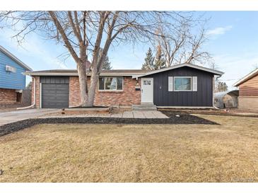 Brick ranch home with updated dark gray siding, landscaping, and a spacious yard at 12516 E Alaska Ave, Aurora, CO 80012