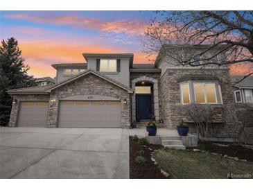 Charming two-story stone home featuring a three-car garage and a covered front entry at 423 N Snowmass Cir, Superior, CO 80027