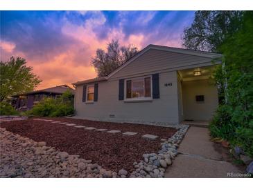 Charming home with gray siding, neat landscaping, and warm exterior lighting at sunset at 1645 Wabash St, Denver, CO 80220