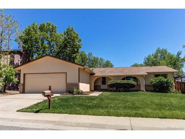 Charming single-story home featuring a manicured lawn, attached garage, and inviting curb appeal at 8228 Marshall Ct, Arvada, CO 80003