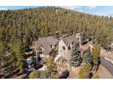 Beautiful exterior view of mountain home surrounded by lush trees at 11421 Belle Meade Dr, Conifer, CO 80433