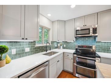 Updated kitchen with white countertops, stainless appliances, and green tiled backsplash at 11457 Nancys Dr, Conifer, CO 80433