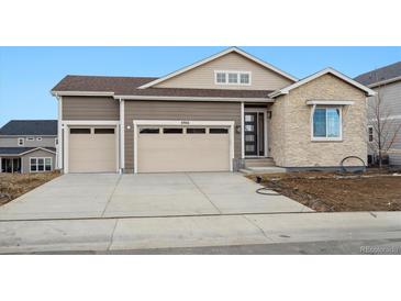 Two-story home featuring a three-car garage, stone facade, and modern architectural details at 6966 E 126Th Pl, Thornton, CO 80602