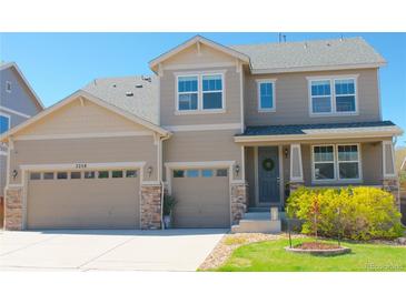 Charming two-story home with a two-car garage and a welcoming front porch, featuring beautiful stone accents and a well-manicured lawn at 7258 Oasis Dr, Castle Rock, CO 80108