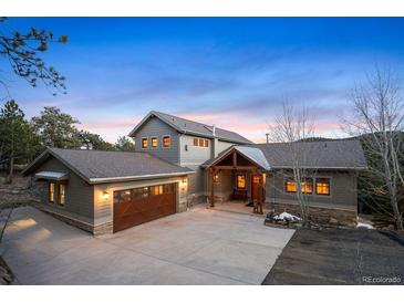 Charming home with a three-car garage, inviting front entrance, and a well-maintained concrete driveway at 1055 Divide View Dr, Golden, CO 80403