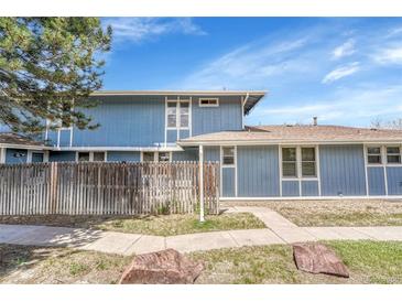 Charming blue two-story home with a fenced yard and mature landscaping at 264 S Newark Cir, Aurora, CO 80012
