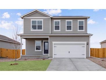 Charming two-story home featuring a two-car garage, well-maintained lawn, and inviting front porch at 2174 Alyssa St, Fort Lupton, CO 80621