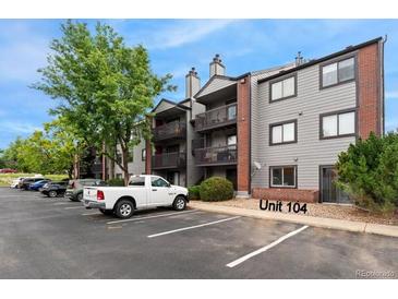 Exterior view of condo building shows balconies and parking with assigned space and easy access to the unit at 6388 Oak Ct # 104, Arvada, CO 80004