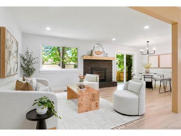 Bright living room featuring a modern fireplace, light wood floors, and ample natural light at 202 Hoover Ave, Louisville, CO 80027