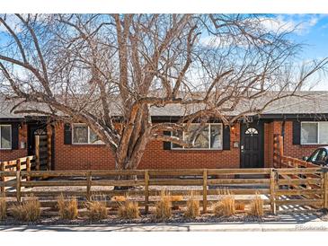 Charming brick home with a lovely front yard and beautiful mature trees providing shade at 5140 W 9Th Ave, Denver, CO 80204