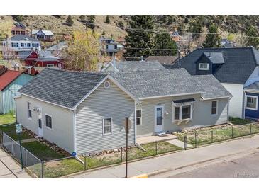Charming home featuring a well-maintained exterior and a tidy front yard with chain link fence at 1104 Miner St, Idaho Springs, CO 80452