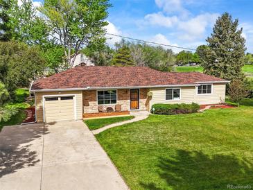 Charming ranch-style home featuring a well-maintained lawn, brick accents, and an inviting front porch at 2445 Vance St, Lakewood, CO 80214
