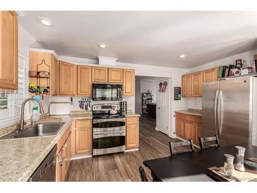 Bright kitchen features stainless steel appliances, wood cabinets, and granite counters at 6105 Needlegrass # 307, Frederick, CO 80530