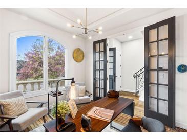 Bright office with a large window, hardwood floors, modern light fixture, and French doors at 2330 N Emerson St, Denver, CO 80205