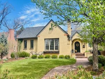 Charming home with a well-manicured lawn, brick walkway, and beautiful tree in a peaceful neighborhood at 1950 Kearney St, Denver, CO 80220