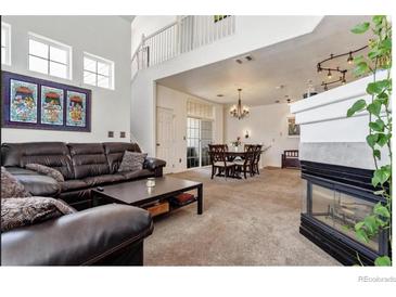 Spacious living room featuring a fireplace, open floor plan, and a lovely staircase at 9530 E Florida Ave # 2001, Denver, CO 80247