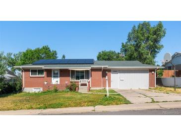 Charming brick home with a well-maintained lawn, solar panels, attached garage, and welcoming front porch at 8140 Pennsylvania Way, Denver, CO 80229