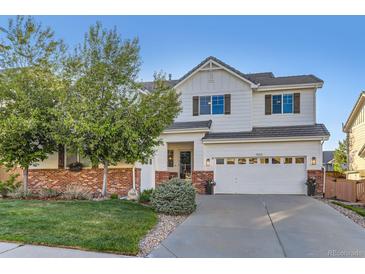 Charming two-story home with red brick accents, green lawn, and a well-maintained yard at 11013 Valleybrook Cir, Highlands Ranch, CO 80130