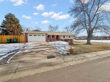 Ranch style home with attached garage, mature tree, and nicely landscaped yard at 7746 S Gray St, Littleton, CO 80128