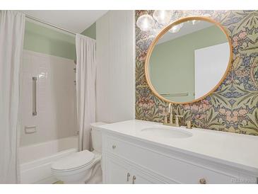 Bright bathroom featuring stylish wallpaper, modern vanity, and a shower with tub at 14001 E Marina Dr # 603, Aurora, CO 80014