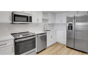 Modern kitchen boasts stainless steel appliances, white cabinets, and sleek countertops at 14001 E Marina Dr # 603, Aurora, CO 80014