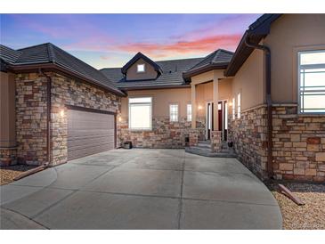 Beautiful home featuring a stone and stucco exterior, three-car garage, and covered front porch at 6532 S Tempe St, Aurora, CO 80016