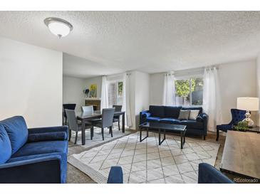 Bright living room featuring modern furniture, a dining area, and ample natural light at 2826 S Lansing Way, Aurora, CO 80014