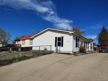 Charming single-story home with white siding, a well-maintained lawn, and a concrete driveway at 311 Elm St, Lochbuie, CO 80603