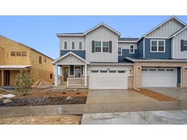 Charming new two-story home with attached two-car garage and yellow front door at 6566 N Nepal St, Aurora, CO 80019