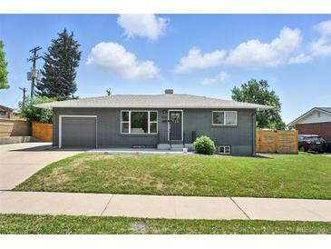 Charming home featuring well-maintained lawn, gray brick exterior, and attached garage at 2714 S Raleigh St, Denver, CO 80236