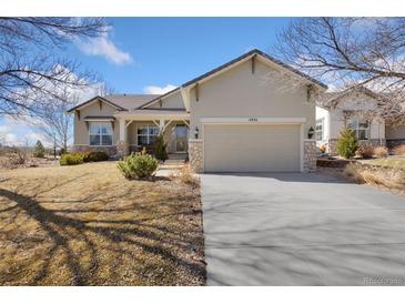Charming single Gathering home with stone accents, manicured lawn, and a two-car garage at 4932 Democrat Dr, Broomfield, CO 80023