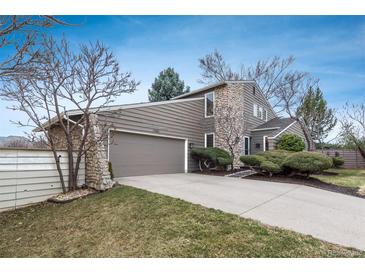 Two story home featuring a stone facade, neutral toned wood siding, and an attached two car garage at 1585 W Briarwood Ave, Littleton, CO 80120