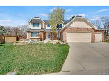 Inviting two-story brick home featuring a well-maintained front lawn and an attached three-car garage at 5603 S Pagosa Ct, Centennial, CO 80015