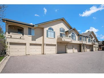 Charming townhome exterior with attached garages and well-maintained landscaping under a bright blue sky at 8777 E Dry Creek Rd # 1426, Englewood, CO 80112