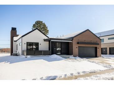 Stunning modern farmhouse exterior with brick and white siding, snowy landscape at 3120 Braun Ct, Golden, CO 80401