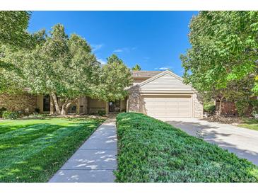 Charming home featuring mature trees, a well-manicured lawn, and a welcoming two-car garage at 6731 S Kearney Ct, Centennial, CO 80112