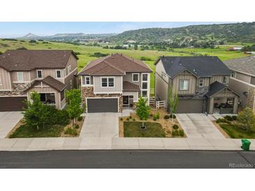 Beautiful two-story home featuring stone accents, a spacious driveway, and manicured landscaping at 2549 Loon Cir, Castle Rock, CO 80104