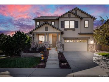 Two-story house with stone accents and a landscaped front yard at 10730 Pinewalk Way, Highlands Ranch, CO 80130