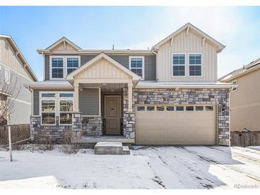 Charming two-story home with a stone facade and attached two car garage at 16278 E 111Th Pl, Commerce City, CO 80022