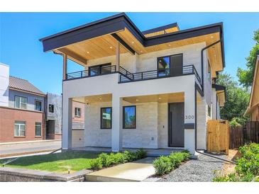 Modern two-story home with a stone facade, balconies, and a well-manicured lawn at 300 S Franklin St, Denver, CO 80209